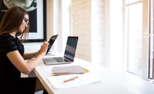 Woman in glasses watching video on touch pad