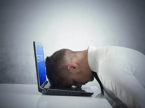 Businessman with blue screen of laptop error