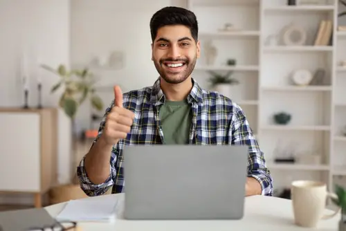  Portrait Of Happy Excited Middle Eastern Man Sitting At Desk Using Laptop