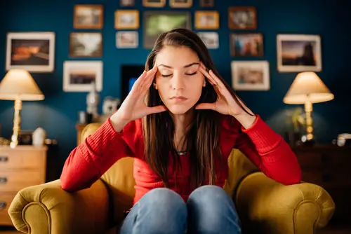 Stressed woman overthinking events alone at home