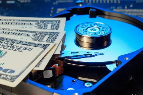 Disassembled hard drive and money. Concept of rise in prices. Selective focus.