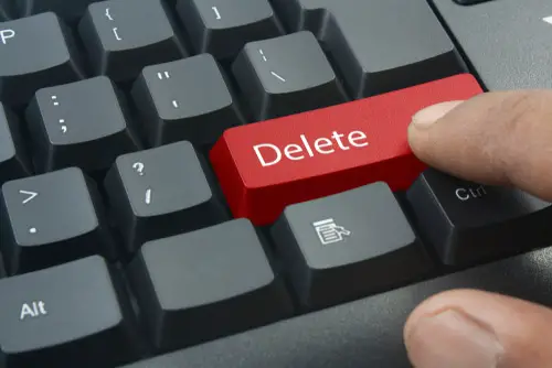 Finger Pressing Red Delete Keyboard Button