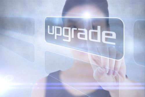 Businesswoman Pointing to Word Upgrade Against Grey